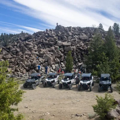a group of people riding a motorcycle down a dirt road